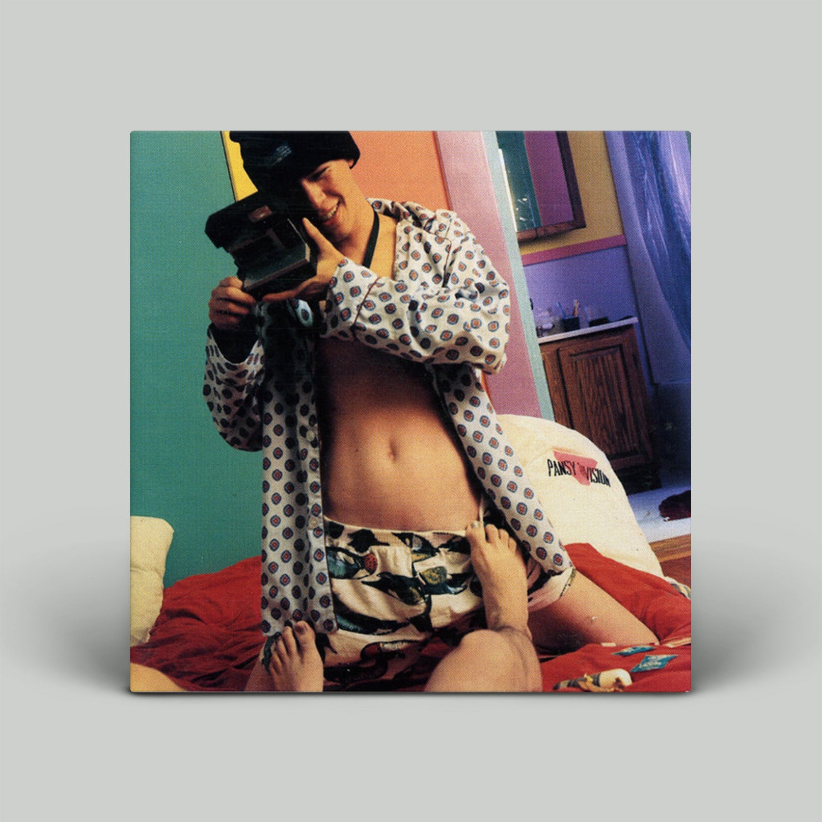 Person taking a selfie with a camera in a colorful room.