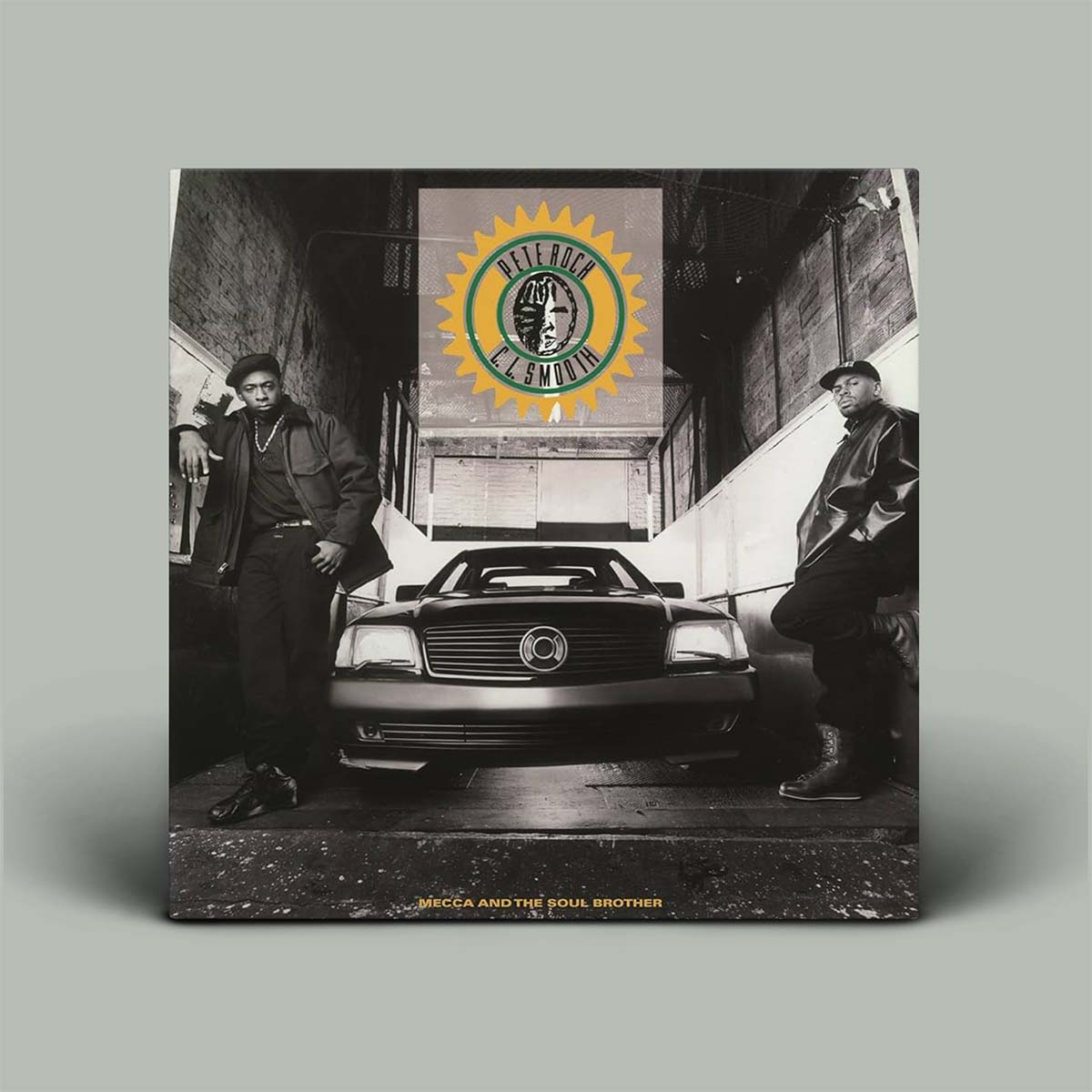 Album cover with two people standing on either side of a car, featuring a logo in the center.