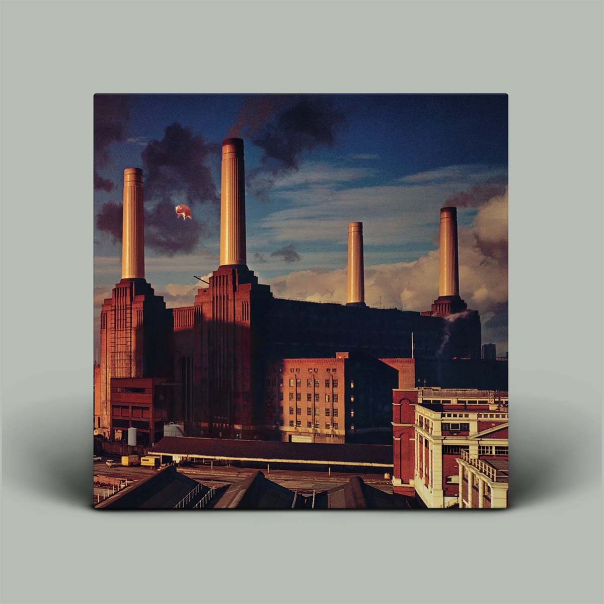 Album cover with industrial building and smokestacks against a cloudy sky