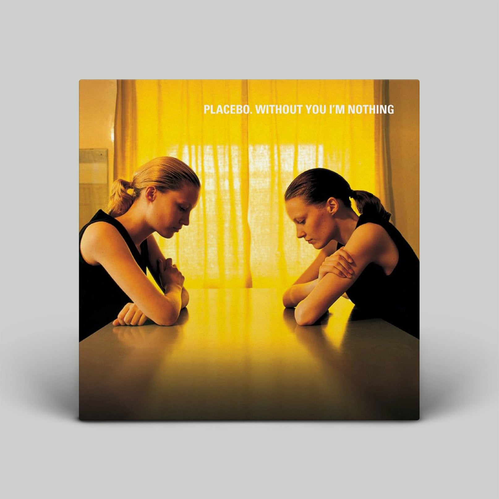 Album cover with two people leaning over a table, featuring the text 'Placebo, Without You I'm Nothing'.