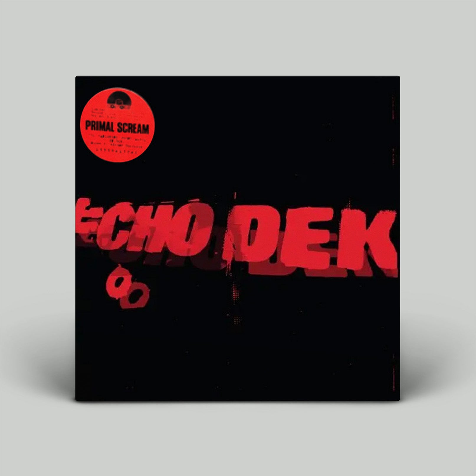 Vinyl record with red text and a Primal Scream label on a gray background