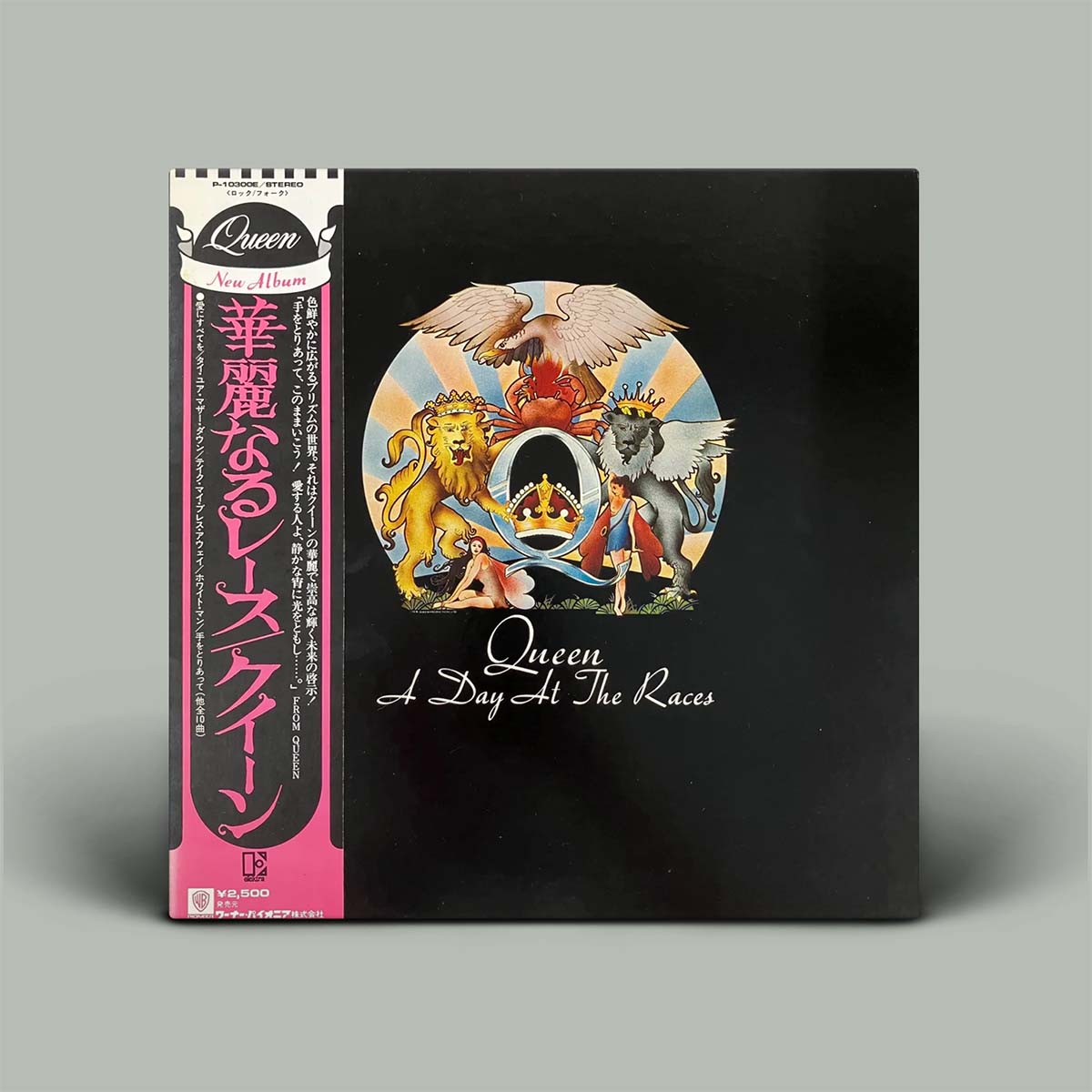 Queen's 'A Day At The Races' vinyl album with Japanese obi strip, shown on a neutral gray background.