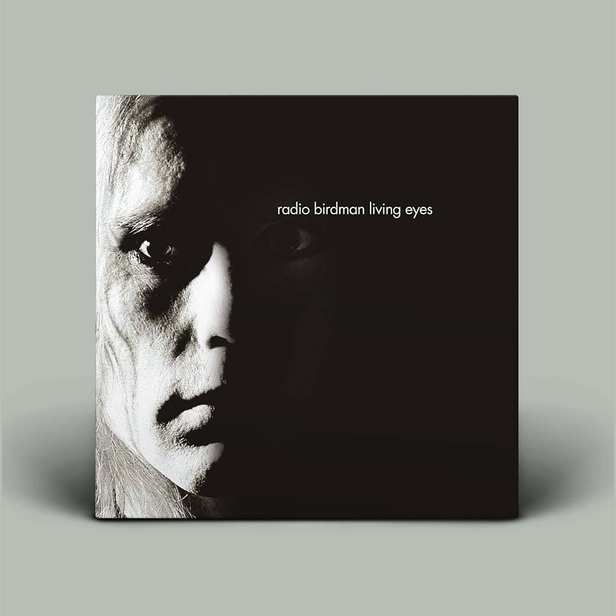 Album cover with a black and white portrait and 'radio birdman living eyes' text on a gray background