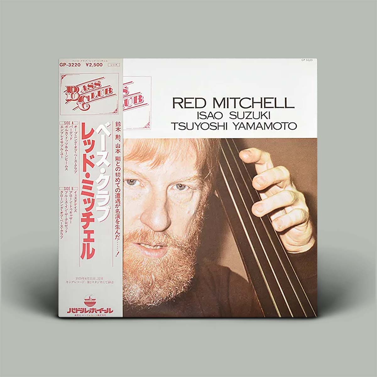 Album cover featuring a person holding a bass with text and branding on a gray background