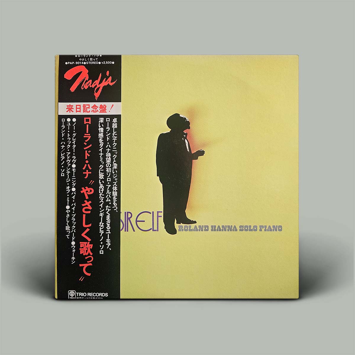Vinyl record cover with a silhouette of a person playing piano on a yellow background