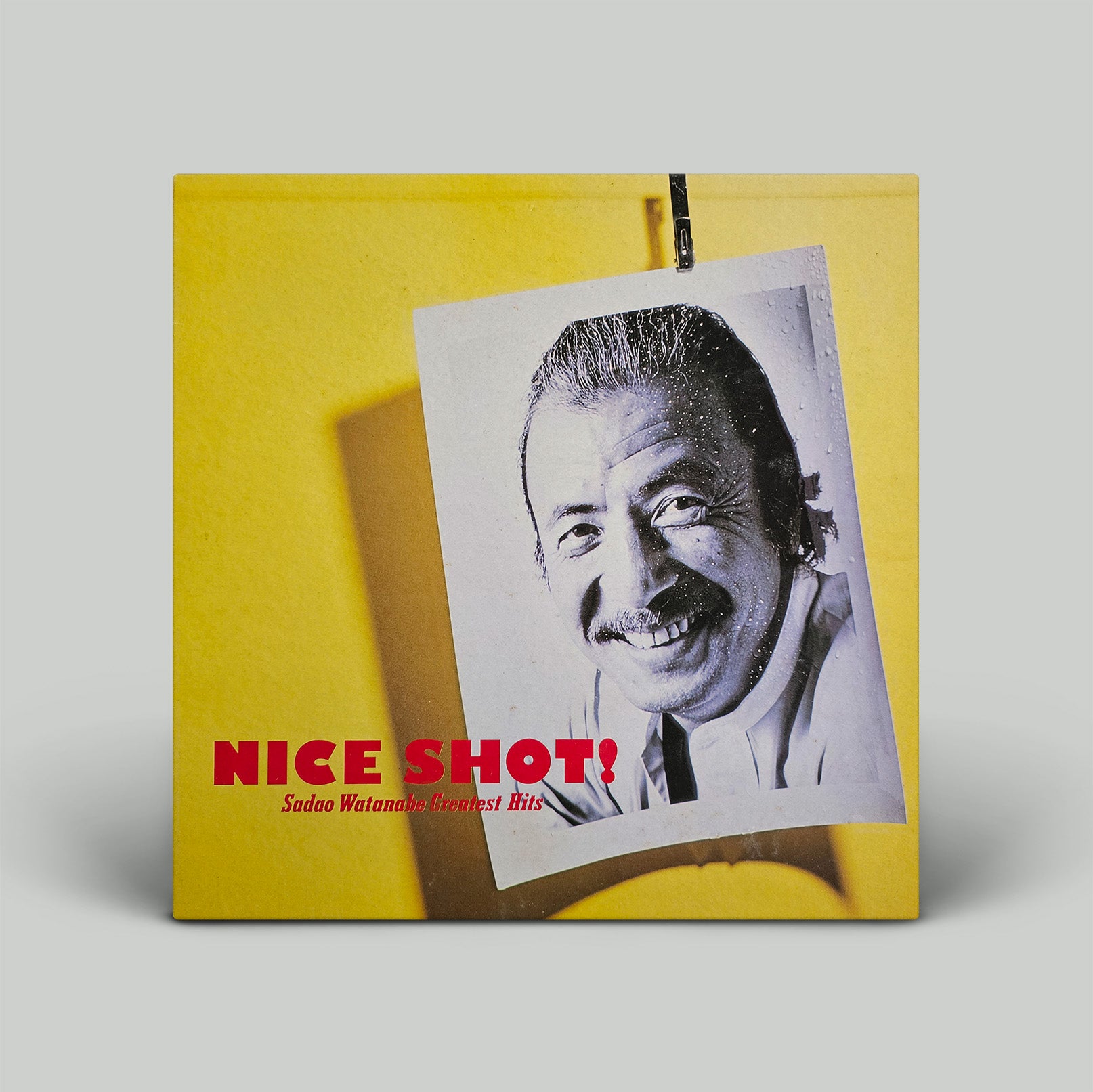 Album cover with a black and white photo of a man and 'Nice Shot!' text on a yellow background