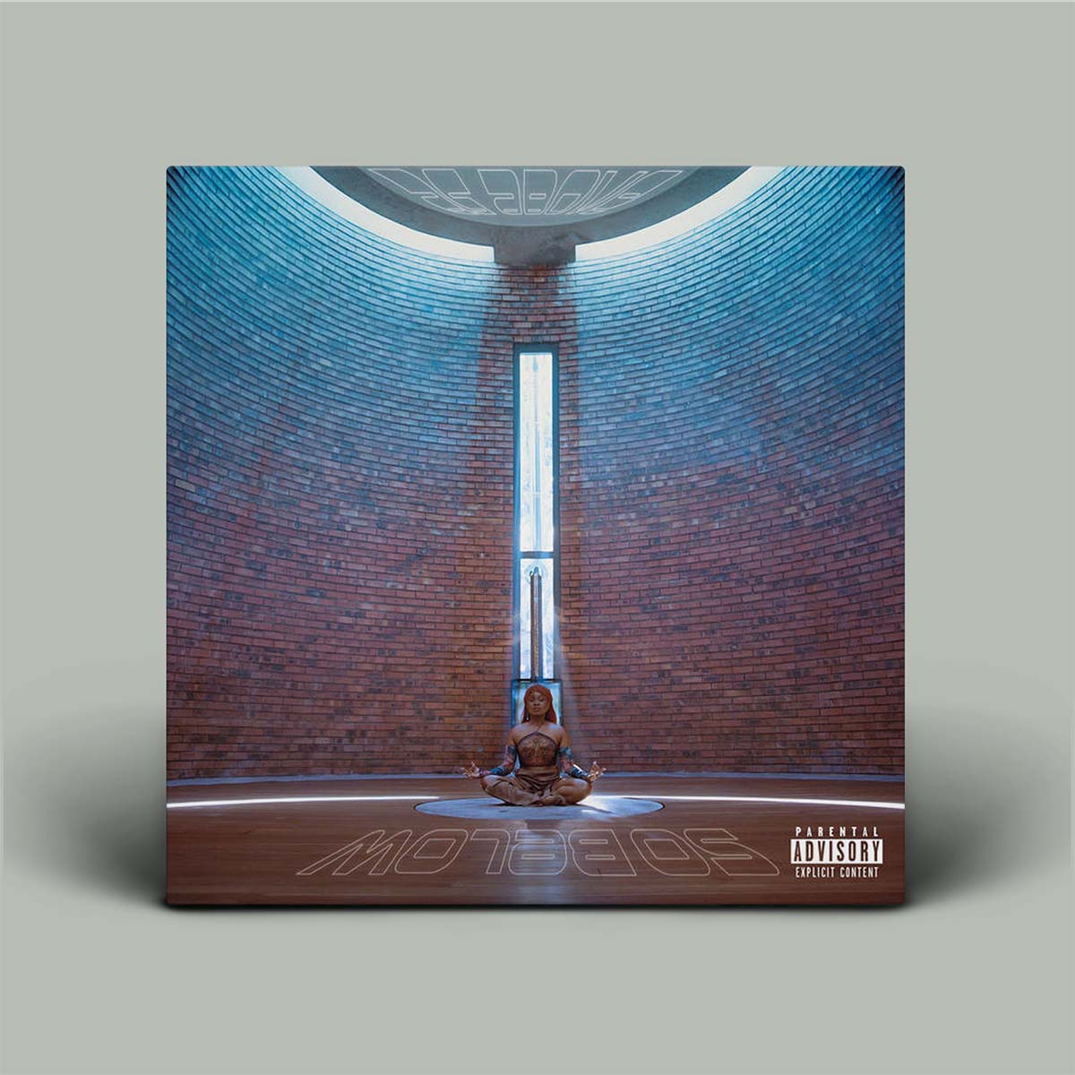 Album cover with a person meditating in a circular room with a central light