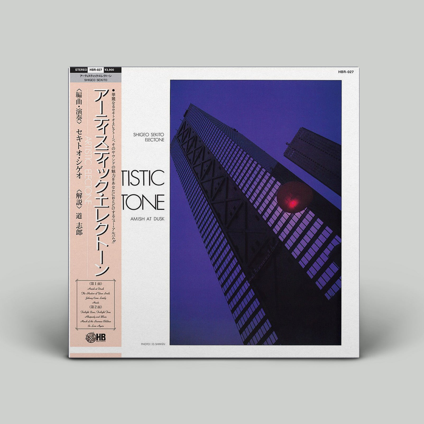 Album cover with purple tinted photo of a highrise building on a white background with Japanese obi.