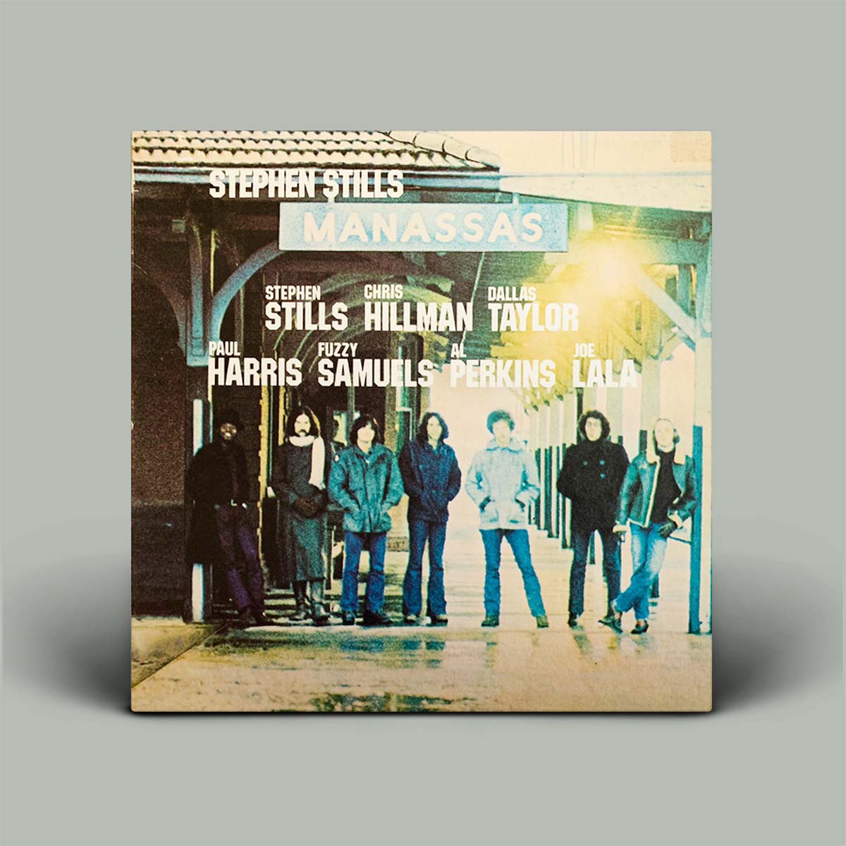 Album cover of 'Manassas' by Stephen Stills featuring a group of people in front of a building.