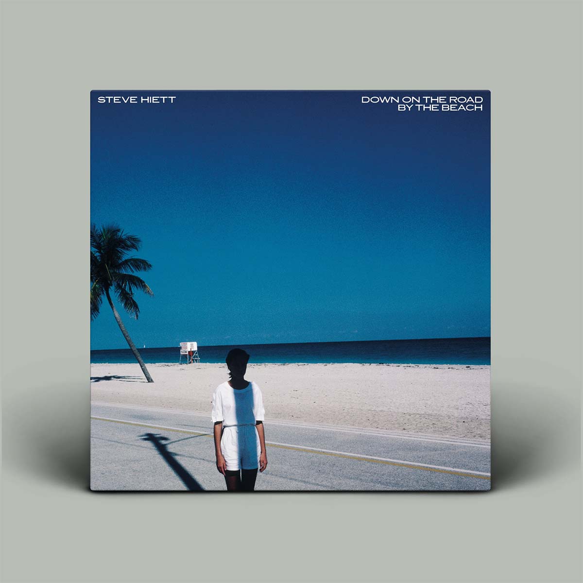 Album cover of 'Down on the Road by the Beach' by Steve Hiett with a person standing on a road leading to a beach.