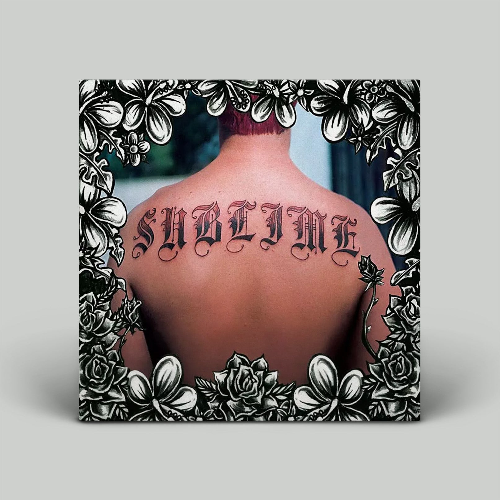 Album cover with photo  of 'Sublime' tattoo on a person's back with floral frame.