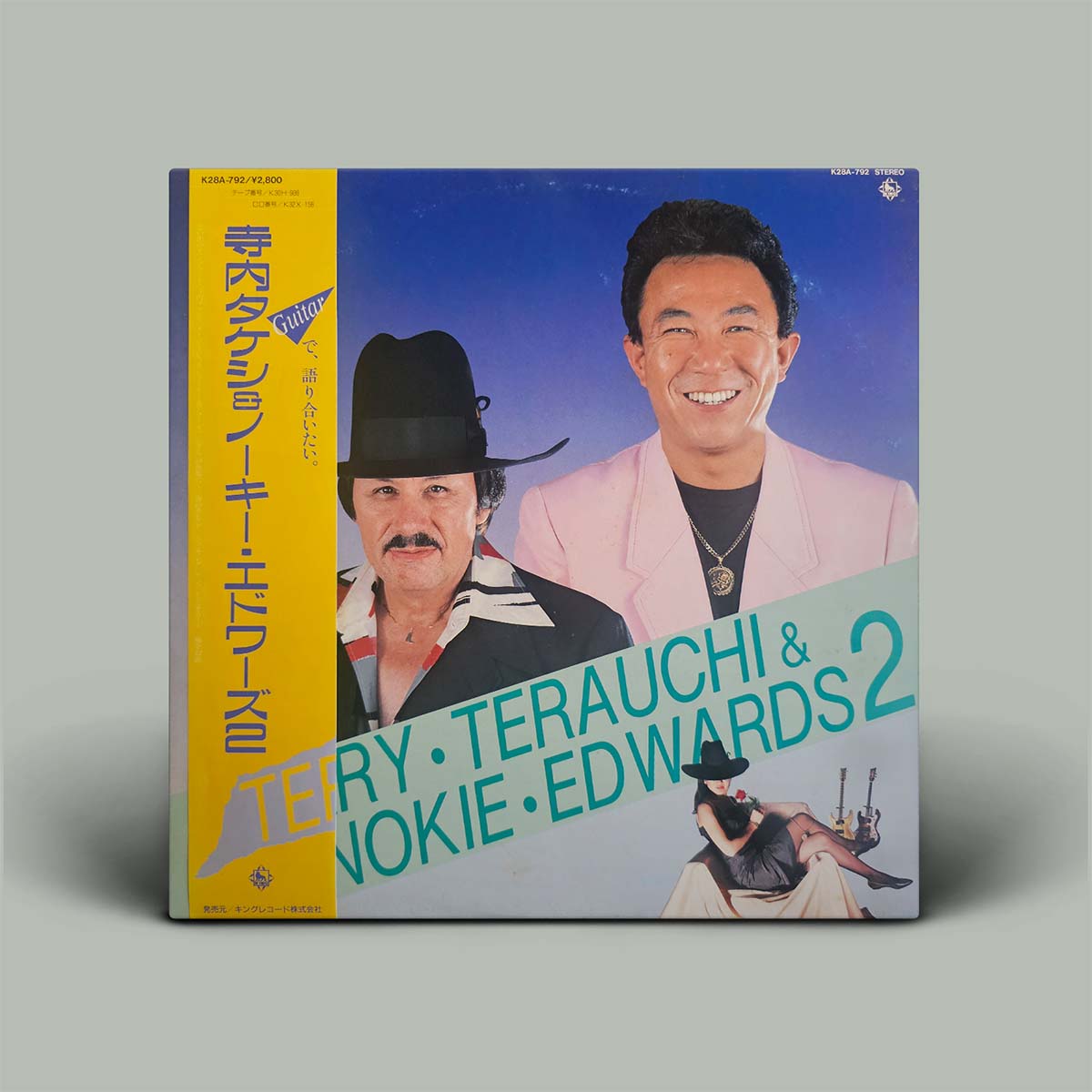 Vinyl record cover featuring two individuals with text and graphics on a gray background