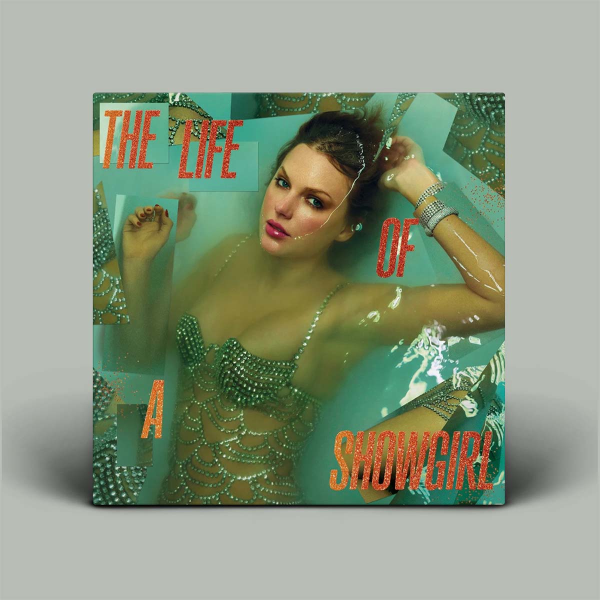 Album cover with a woman in a beaded outfit underwater, text 'The Life of a Showgirl' on a gray background