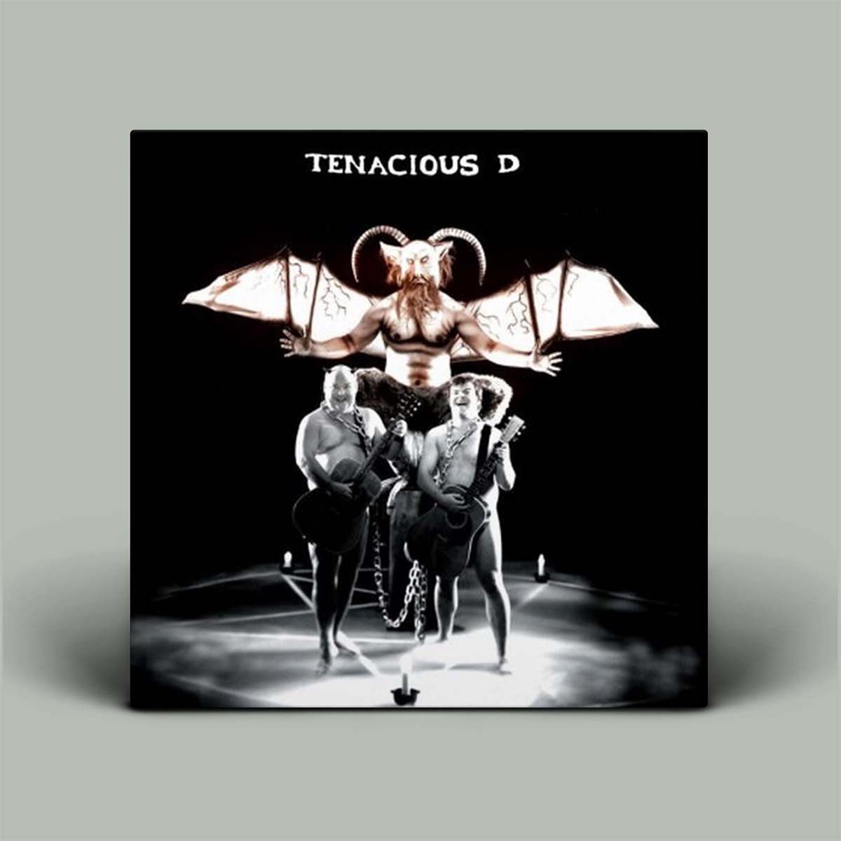 Album cover for Tenacious D featuring a satanic-themed illustration with two people and a demon-like figure.