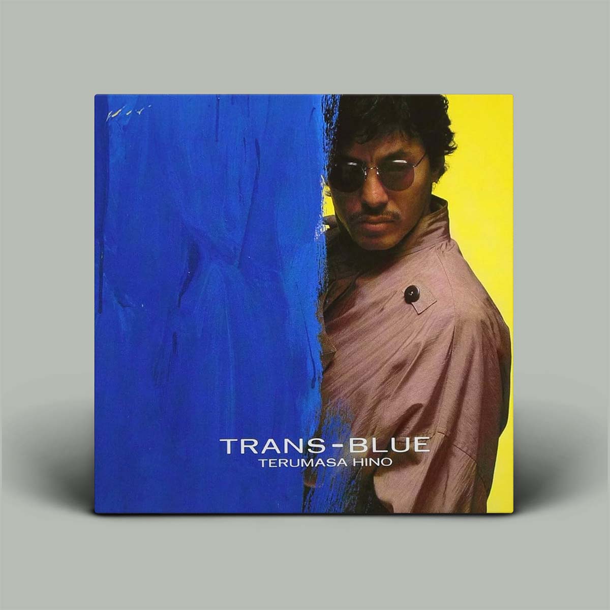 Album cover of 'Trans-Blue' by Terumasa Hino with a person peeking from between blue and yellow sections.