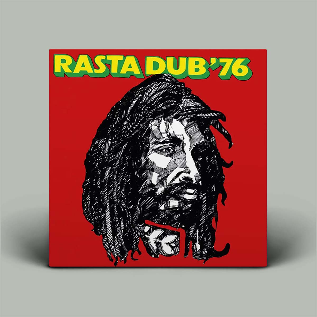 A square album cover or print featuring a stylized black-and-white portrait of Bob Marley on a bright red background, with the text 'RASTA DUB '76' in yellow letters outlined in green at the top. The item is photographed standing against a plain light gray background.