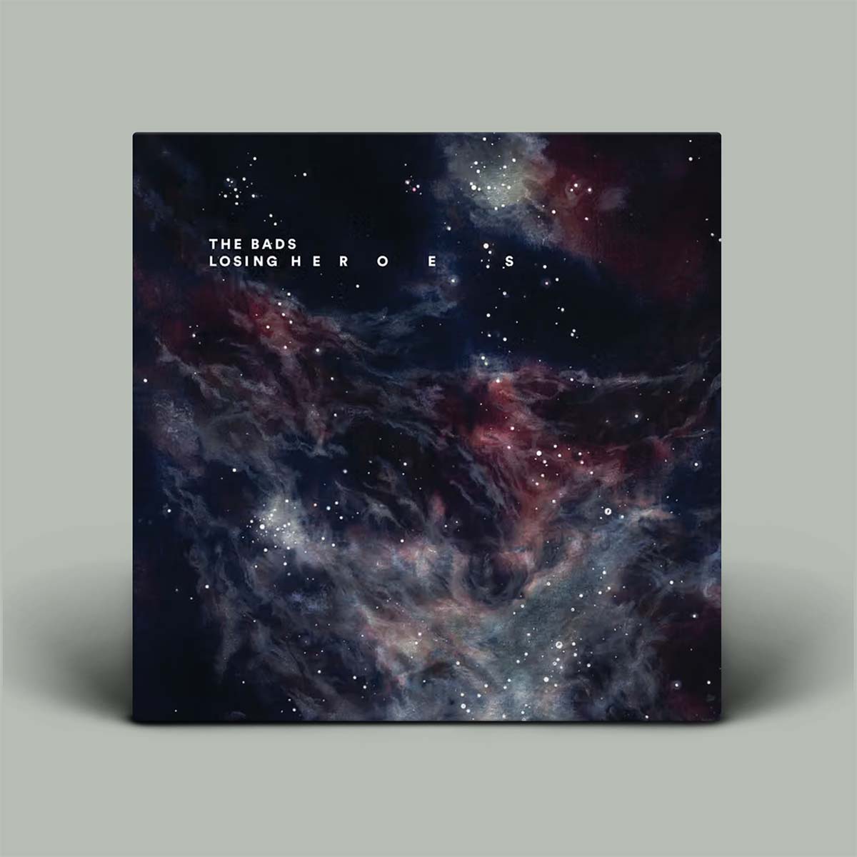 Album cover featuring a dark cosmic nebula scene with stars and the text 'THE BADS LOSING HEROES' near the top, shown against a plain light gray background.
