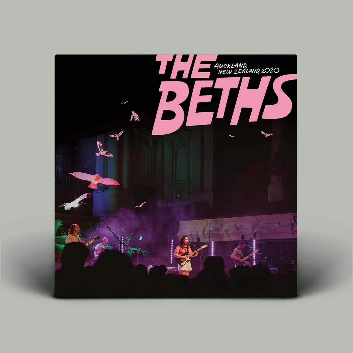 Album cover for 'The Beths' concert in Auckland, New Zealand 2020 with pink text and stage image.
