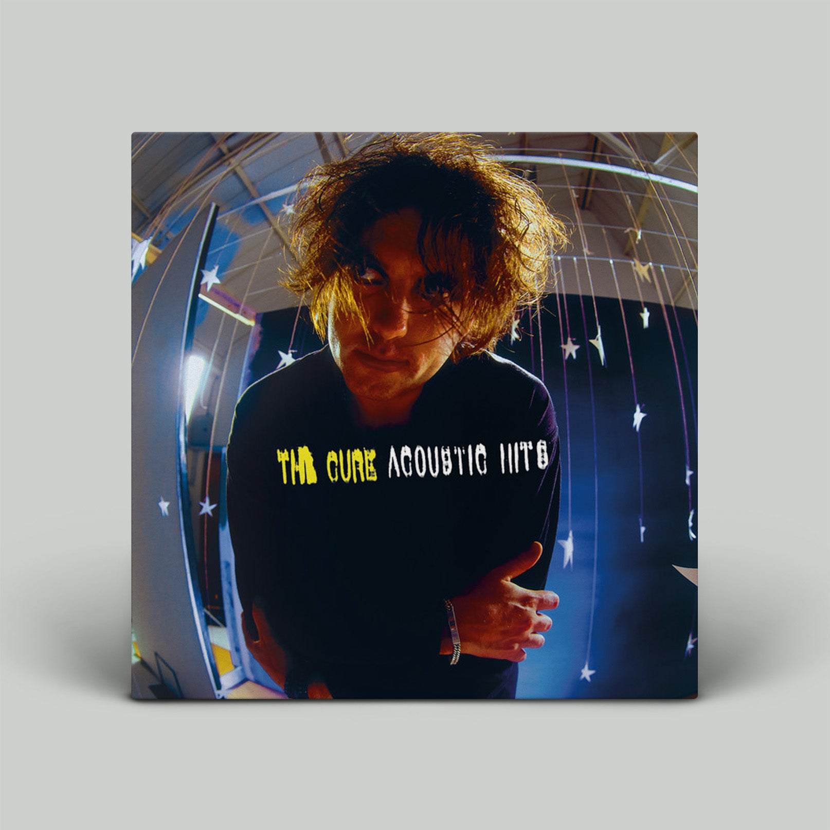 Album cover for 'The Cure Acoustic Hits' with a person in front of a starry background.