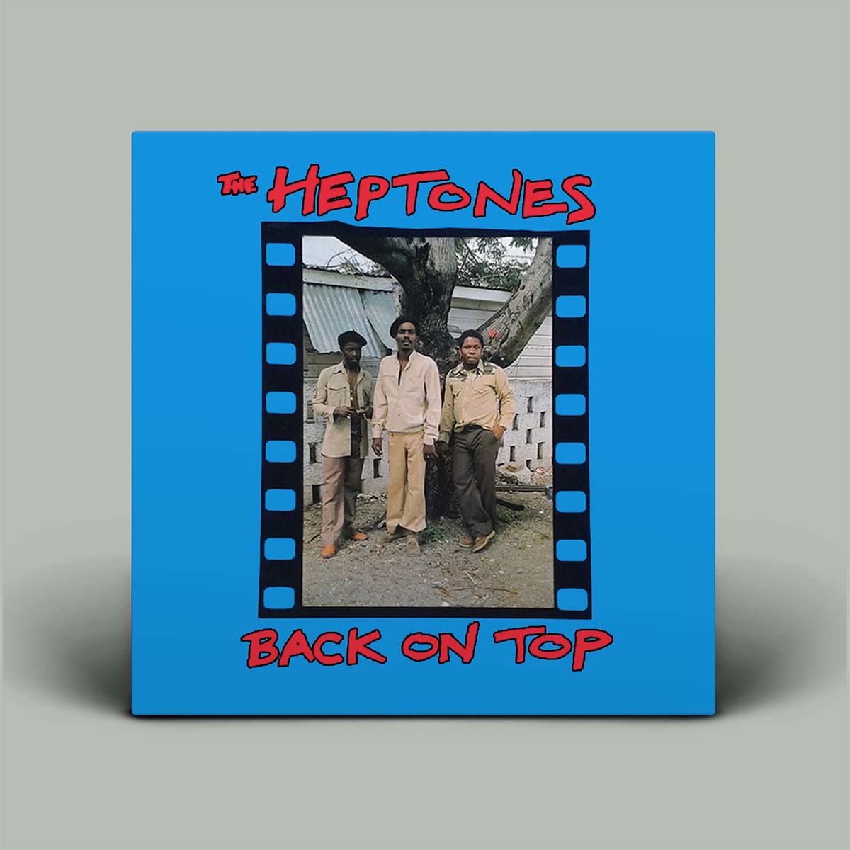 A square blue album cover for 'Back On Top' by The Heptones, featuring a vintage-style photo of three men framed by a black film strip border, set against a neutral gray background.