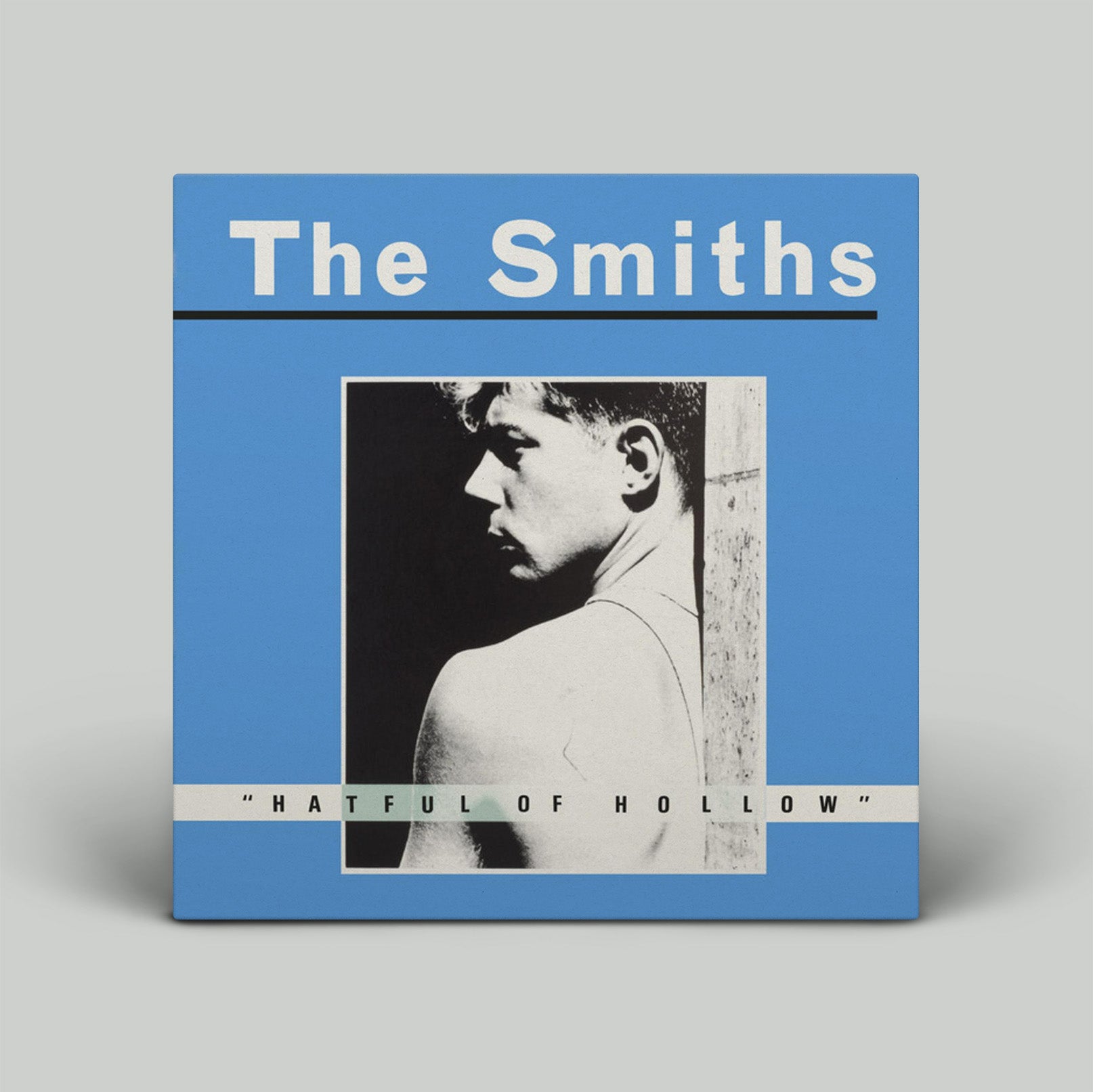 Album cover for 'The Smiths' with a blue background and black and white photo of a man.