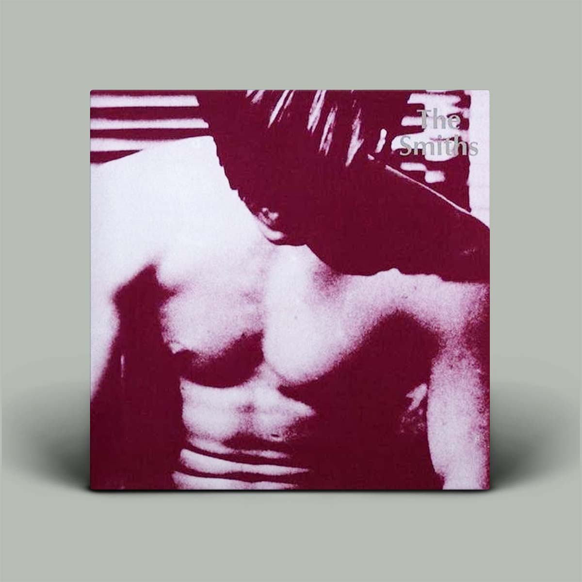 A square album cover for The Smiths, featuring a high-contrast, stylized photo of a shirtless man in deep magenta and white tones, shown standing against a solid gray background.
