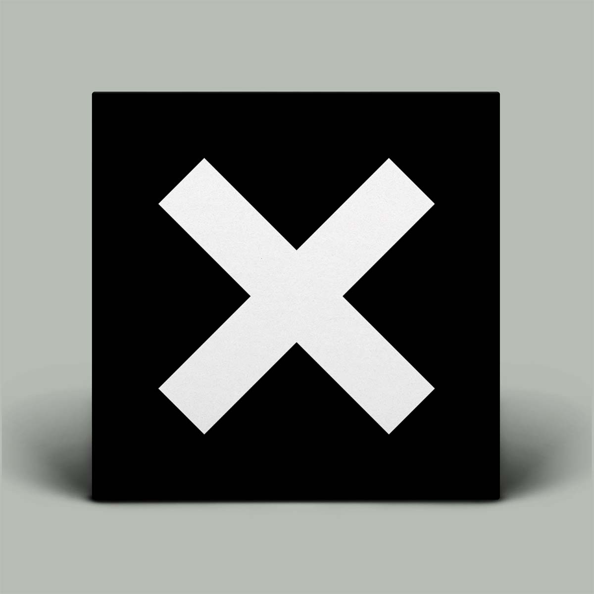 This image features the cover of The XX's debut album, titled simply "XX." The cover design is strikingly minimalist, displaying a large white 'X' on a black background.