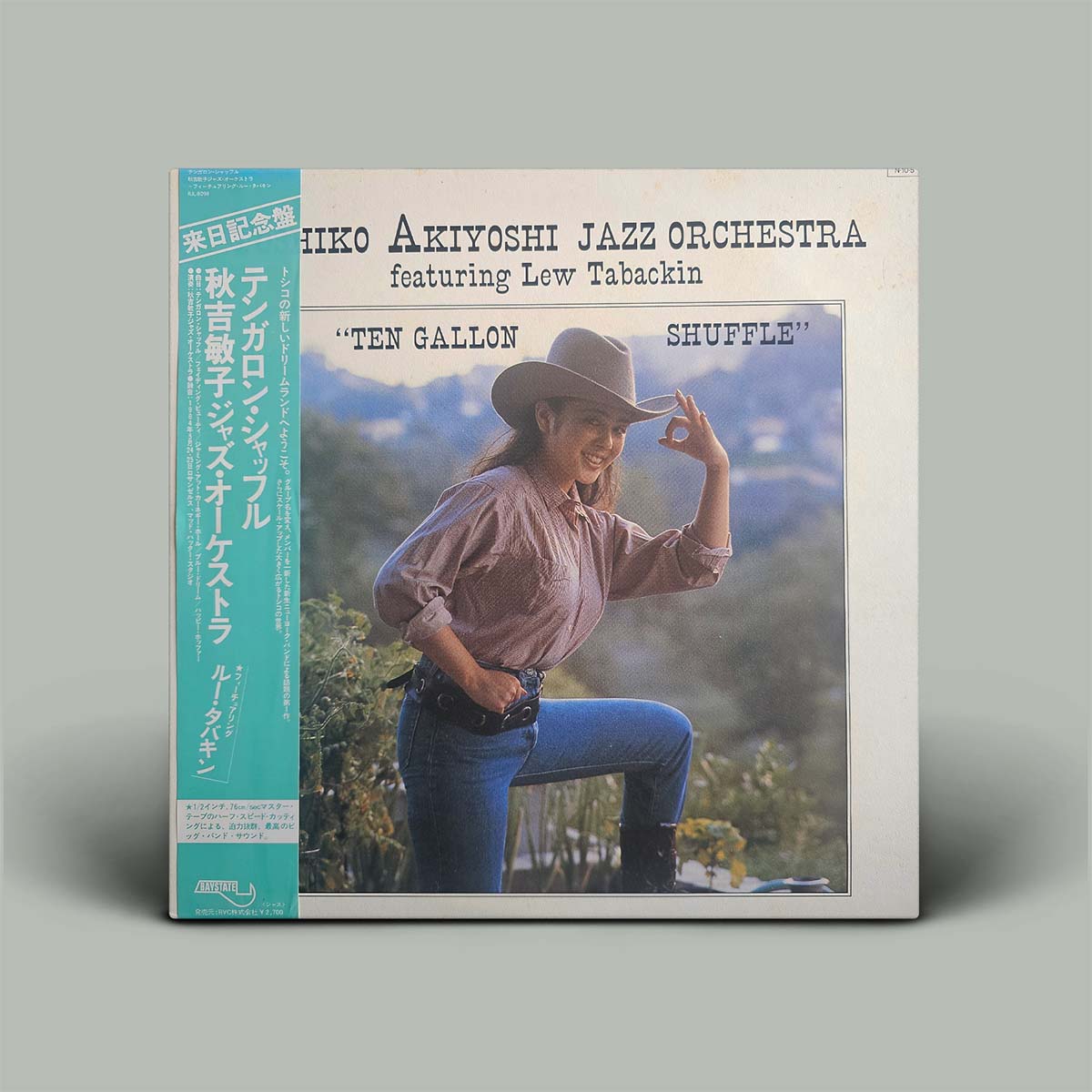 Album cover of Iiko Akiyoshi Jazz Orchestra featuring Lew Tabackin with a person in a cowboy hat and jeans.