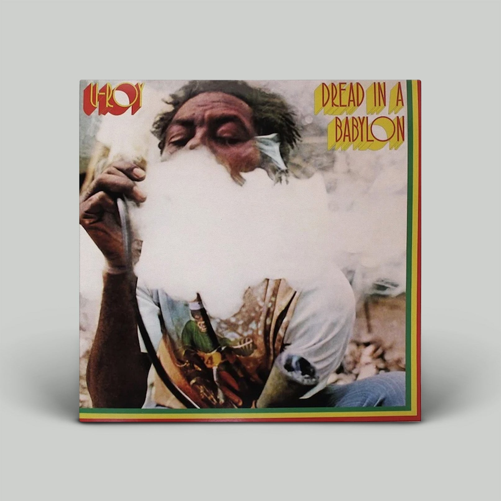 Album cover with a person smoking, text 'Dead in a Babylon', and a colorful border.