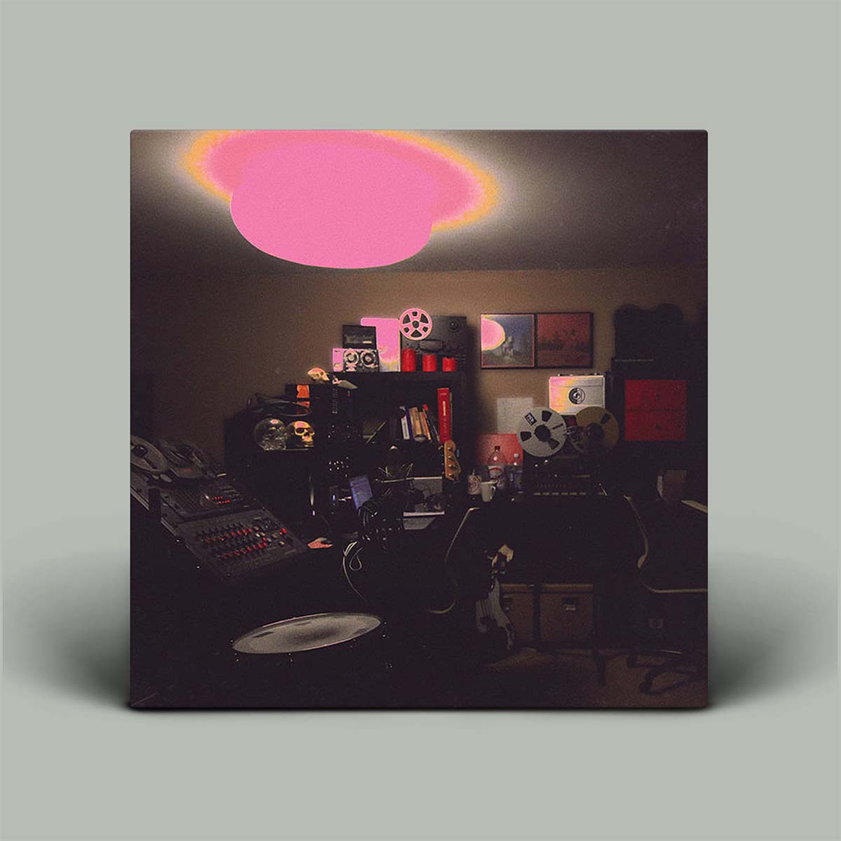 Album cover with a dark room filled with music equipment and a pink light.
