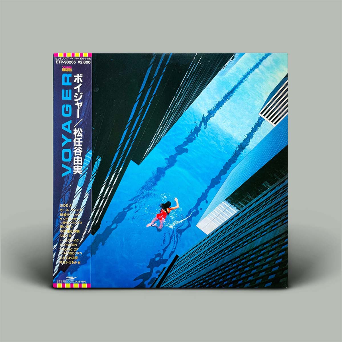 A vinyl record album cover FOR 'VOYAGER' (松井五郎), featuring a striking blue-toned photograph of a swimmer underwater in a pool, framed by tall modern buildings. The left spine displays the artist's name in Japanese and English.